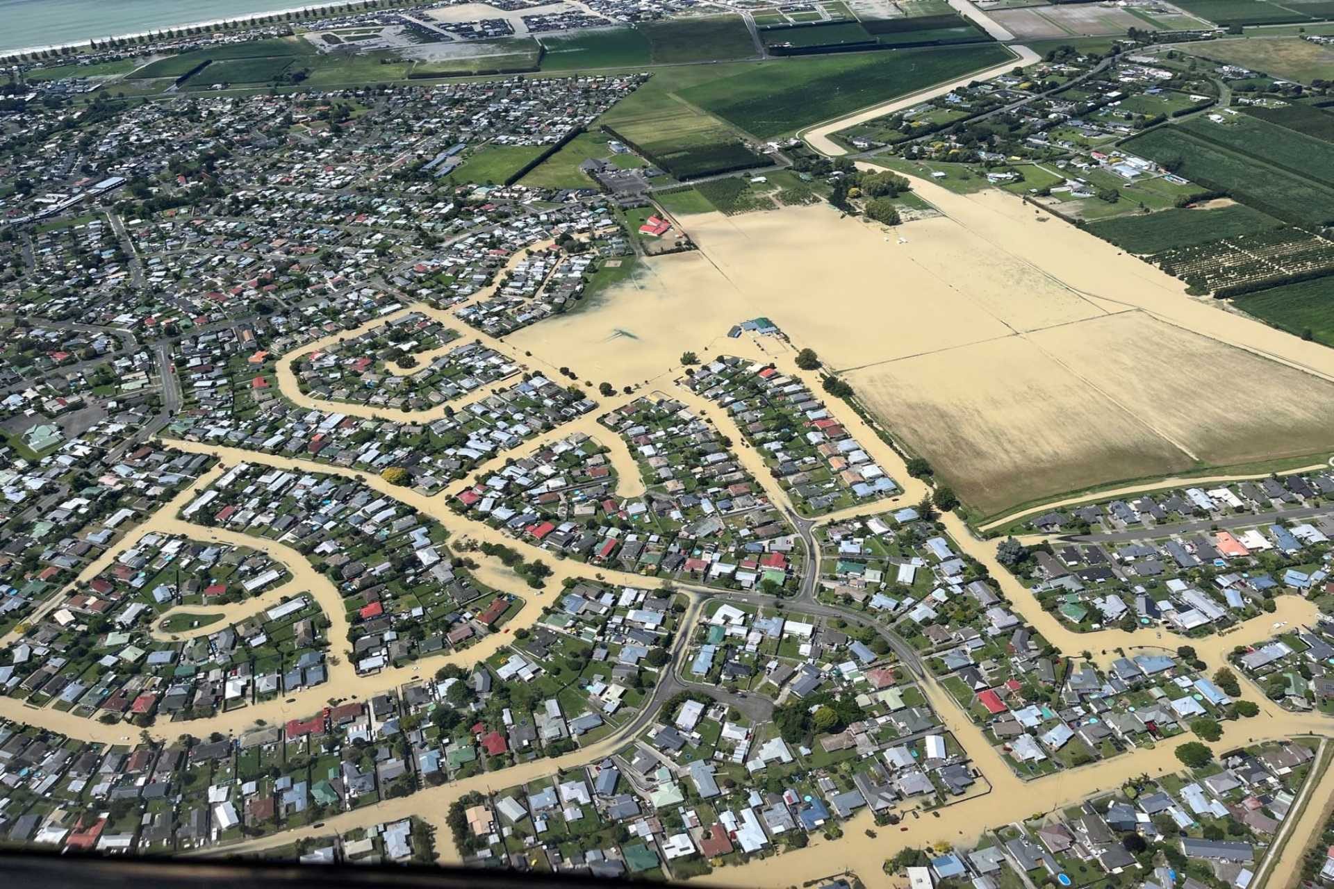 Aerial view of flooded residential area with muddy water covering streets